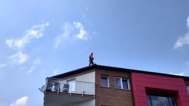 Prace konserwacyjne rynien na dachu budynku wielorodzinnego.